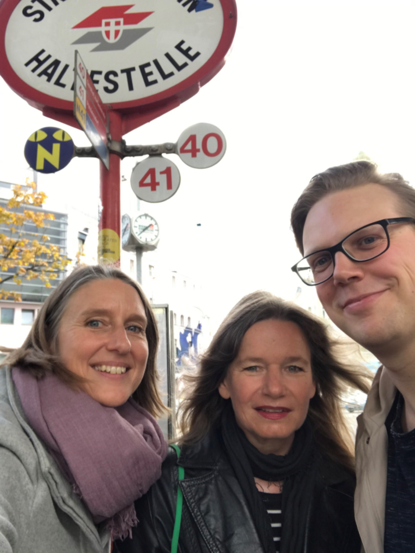 Foto der drei Projektmitglieder der Universität Wien vor einem Straßenbahnschild