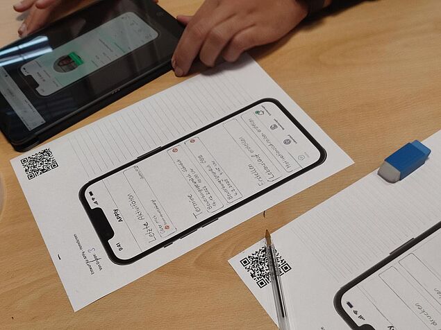 Foto von einem auf Papier gedrucktem Smartphone-Screen, auf welchem Jugendliche Ideen festhalten, was beim Öffnen der Bewerbungsapp angezeigt werden soll