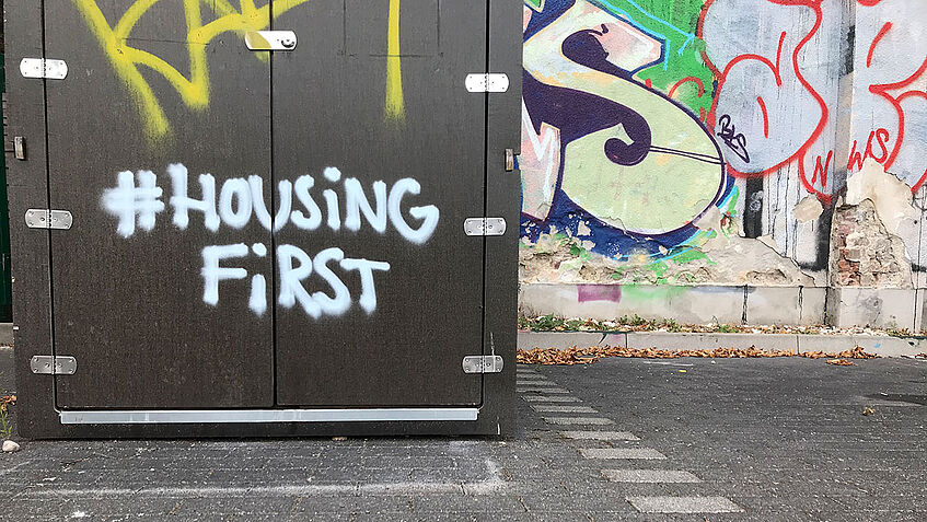Grafiti mit Schriftzug 'Housing first'