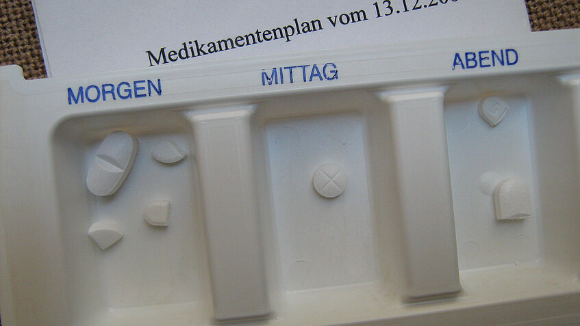Eine weiße Medikamentendosierungsschachtel mit blauer Schrift 
