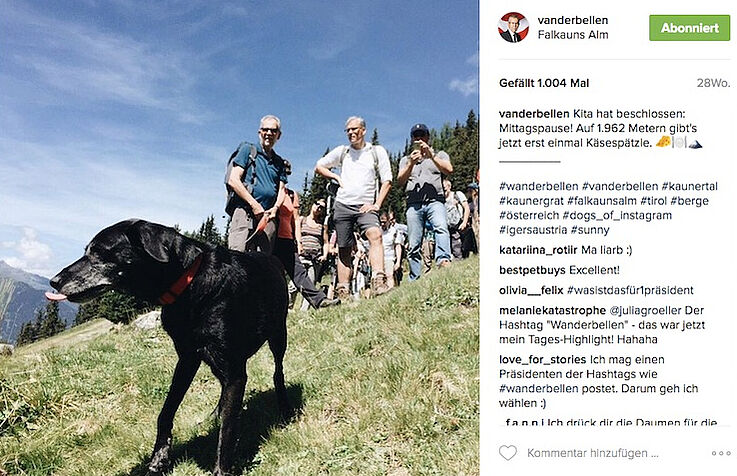 Instagram Post von Van der Bellen, Foto von ihm mit schwarzem Hund und einer Gruppe an Leuten, beim Wandern