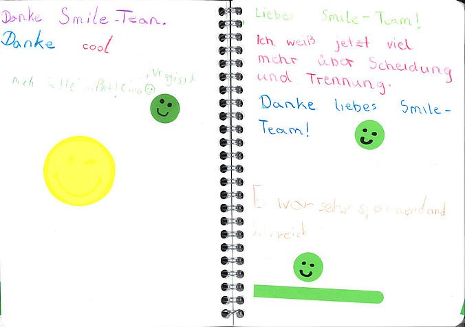 Scan einer Doppelseite des SMiLE-Gästebuch. In Kinderhandschrift steht unter anderem: "Ich weiß jetzt viel mehr über Trennung. Danke liebes SMiLE-TEam!" 